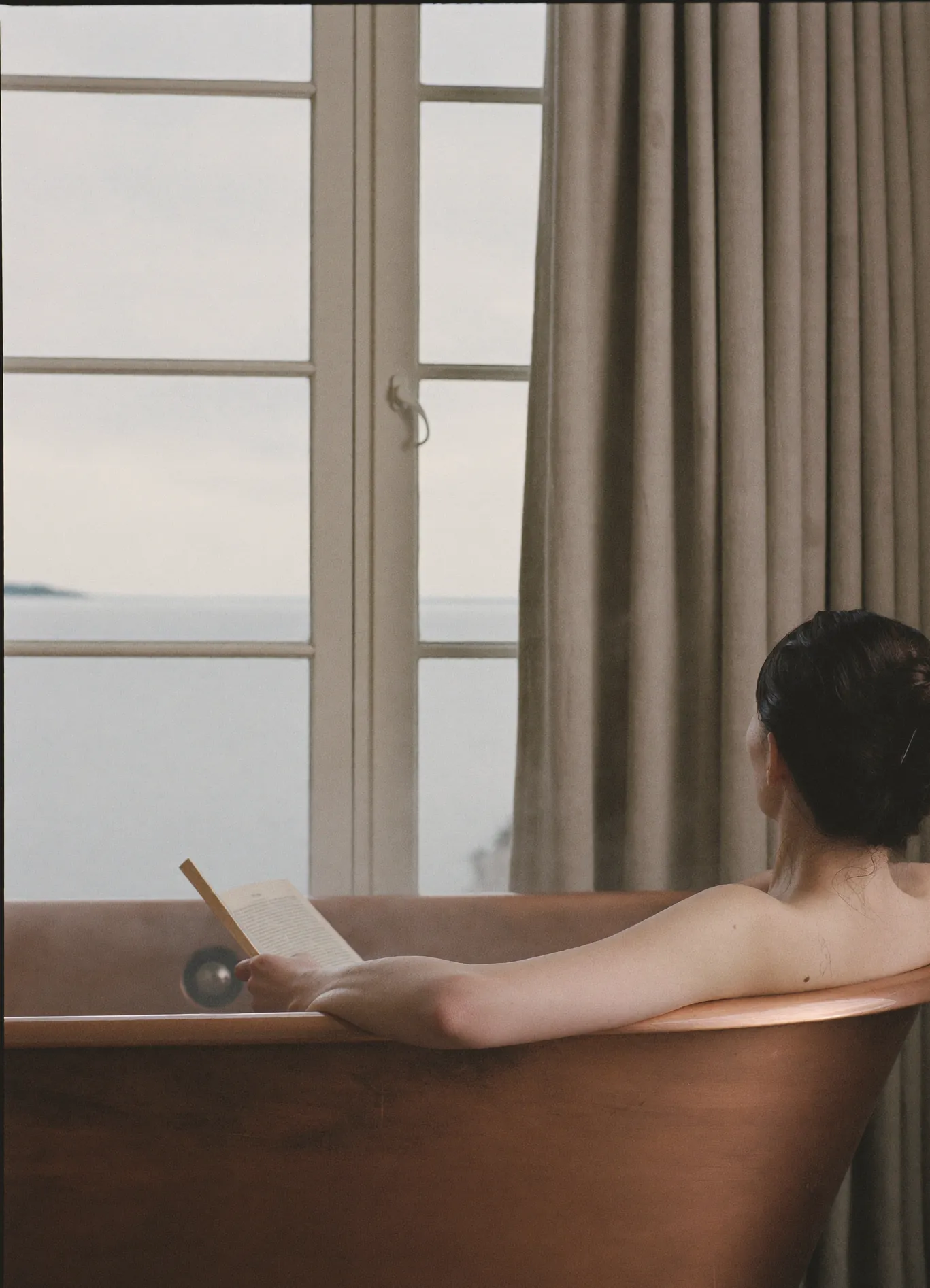 Reading in the copper bath with a view of the sea